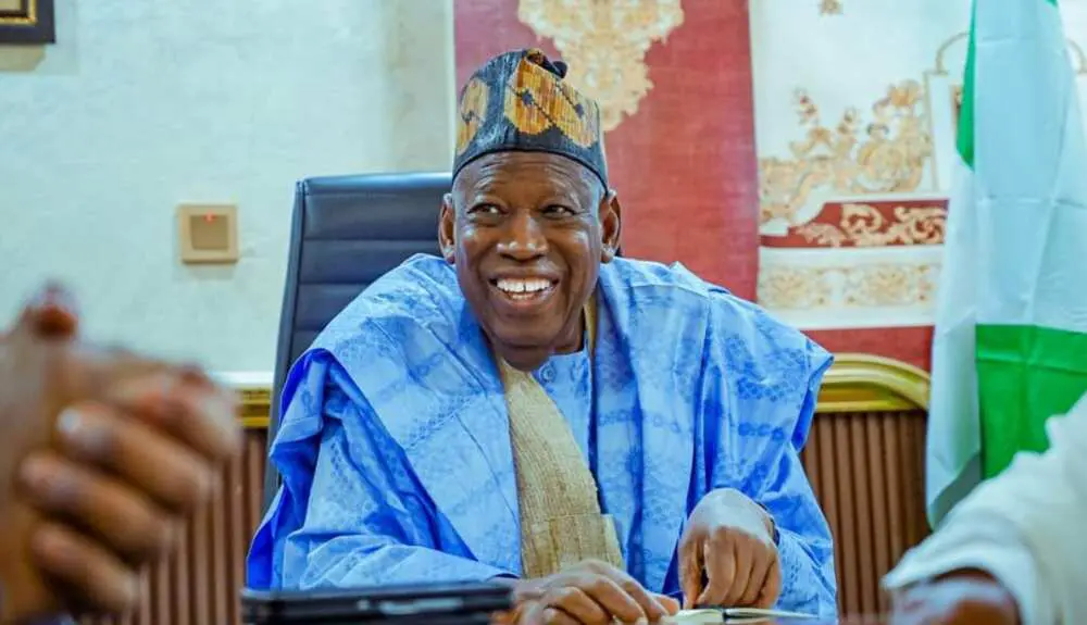 Policeman under fire for tying Ganduje’s shoelaces in viral video